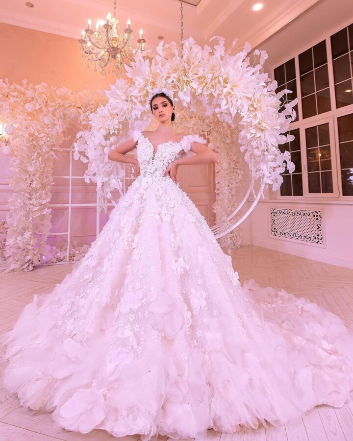 a young woman in a wedding dress, with a tiara on her hair, in a hall with elegant wedding décor