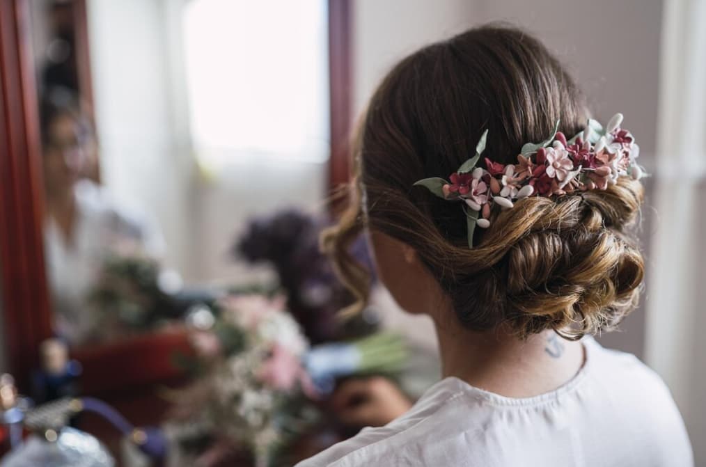 Bride with an intricate floral hairpiece reflecting in a mirror