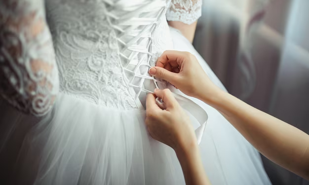 Hands tying a wedding dress