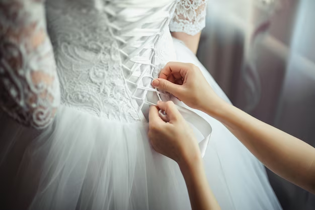 Hands tying a wedding dress