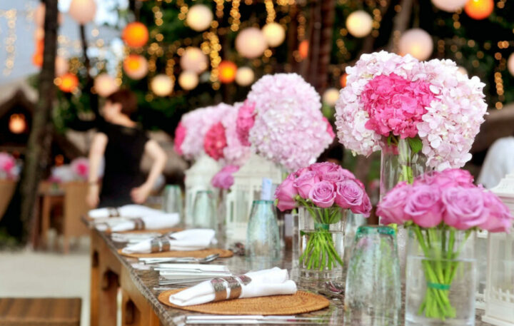 Outdoor wedding table with pink flowers and festive lights