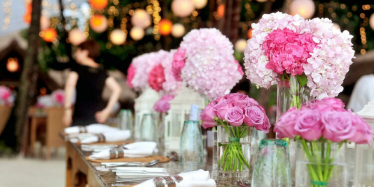 Outdoor wedding table with pink flowers and festive lights