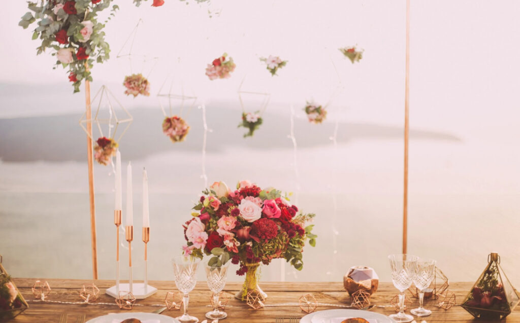 Wedding table with floating flowers and a red and pink centerpiece