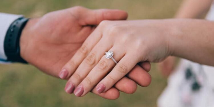 The wedding ring is placed on the bride's finger