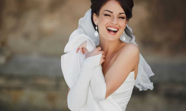 A bride in a white veil and gown, smiling