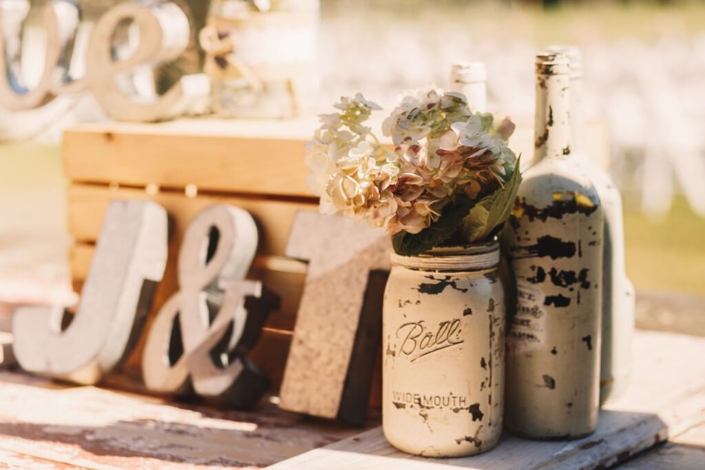 White old bottles with beige flowers stand before wooden letters