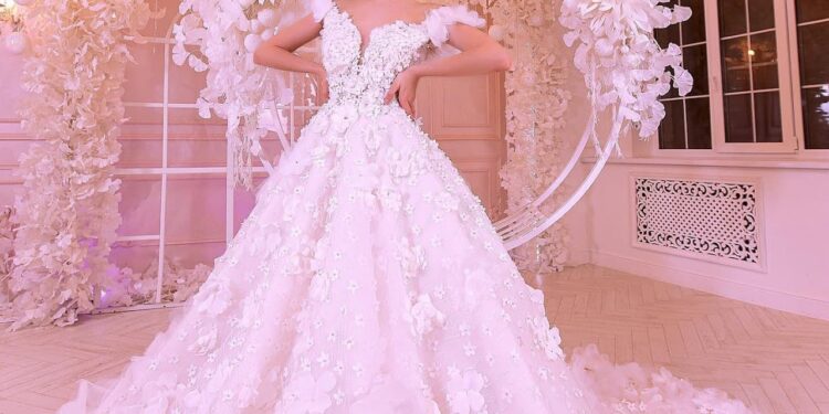 a young woman in a wedding dress, with a tiara on her hair, in a hall with elegant wedding décor
